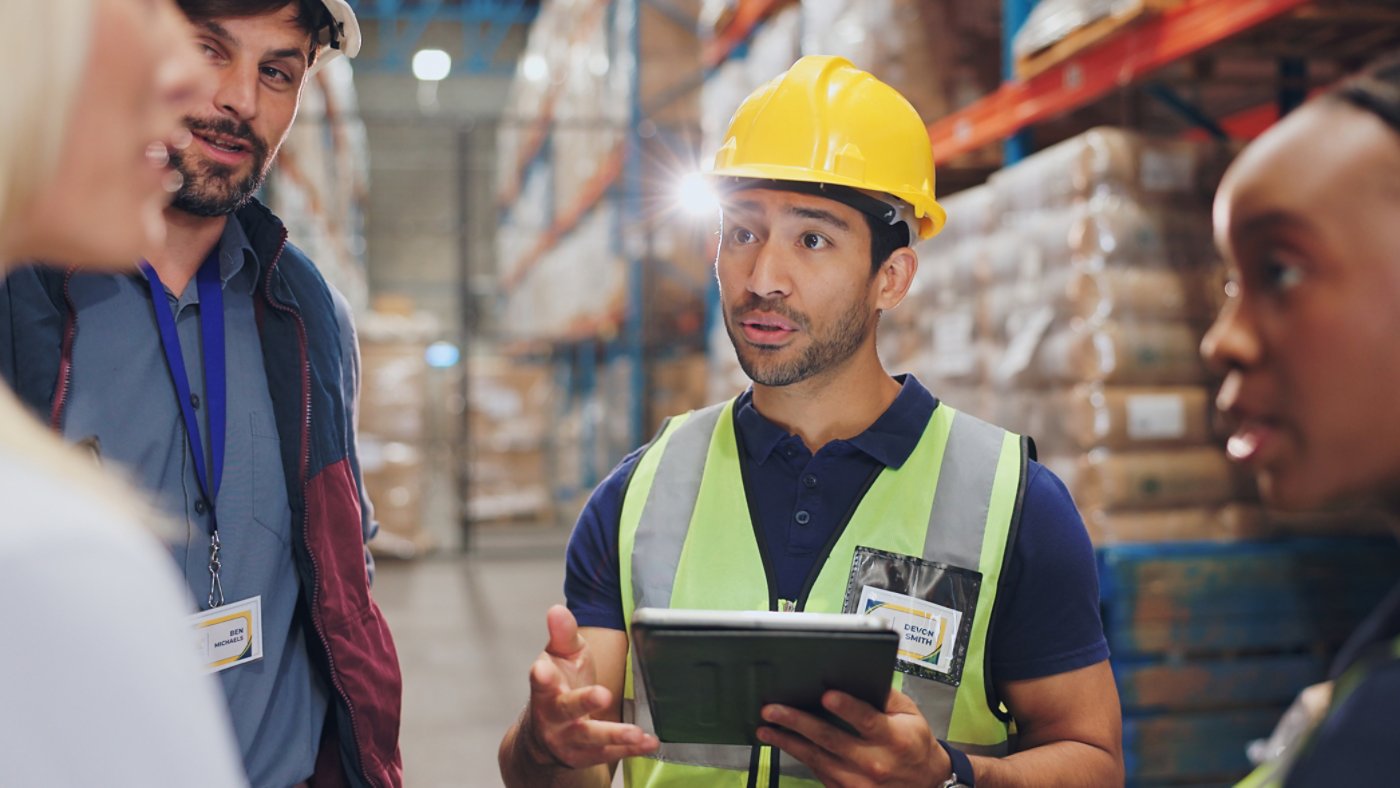 Man, tablet and group in warehouse for logistics with discussion, planning or check inventory. Women, people and team with digital touchscreen on app for supply chain, inspection and cargo in factory