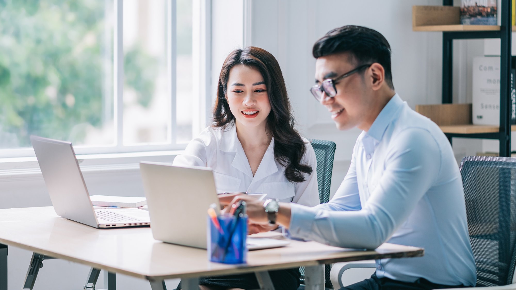 Two Asian businesspeople working at office