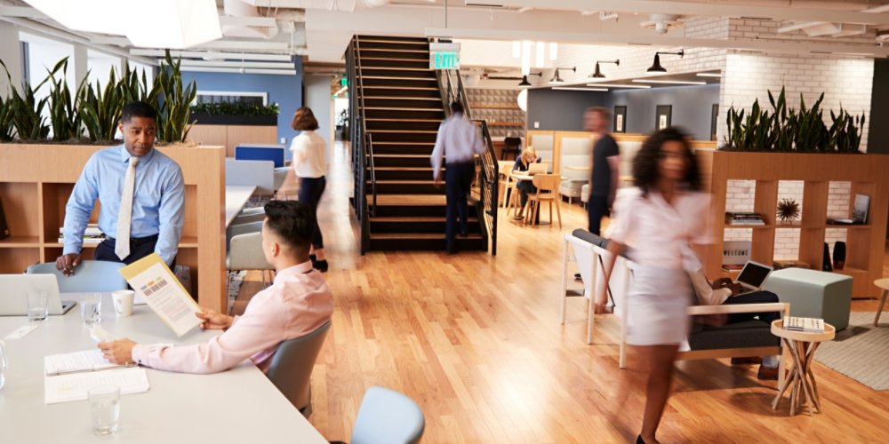 Interior View Of Modern Open Plan Office With Blurred Businessmen And Businesswomen