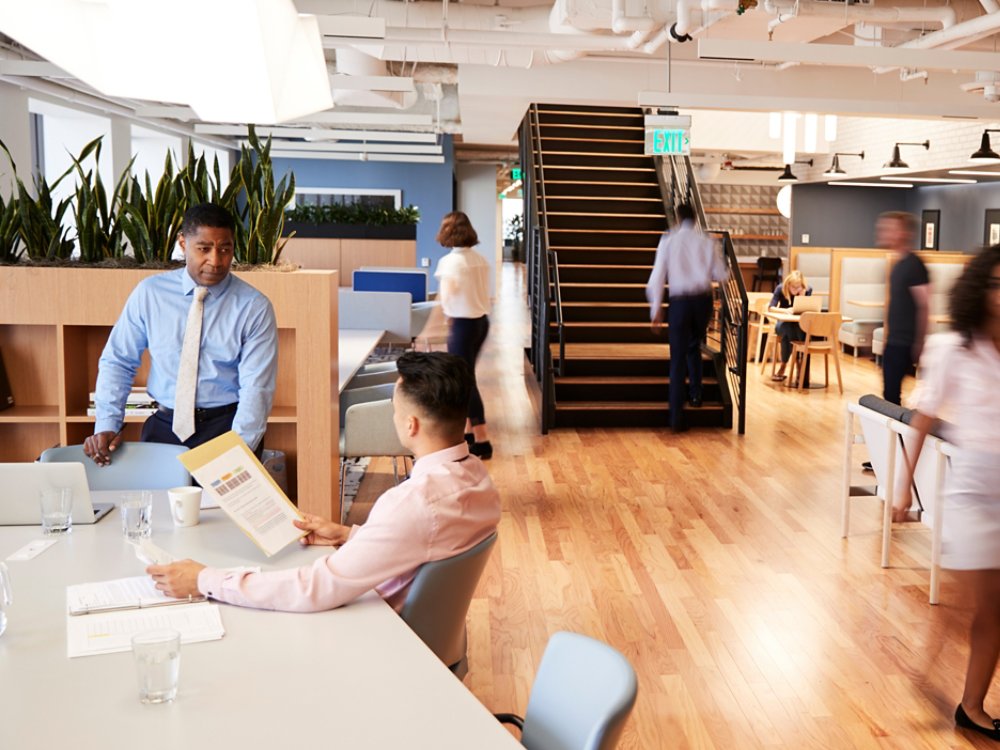 Interior View Of Modern Open Plan Office With Blurred Businessmen And Businesswomen