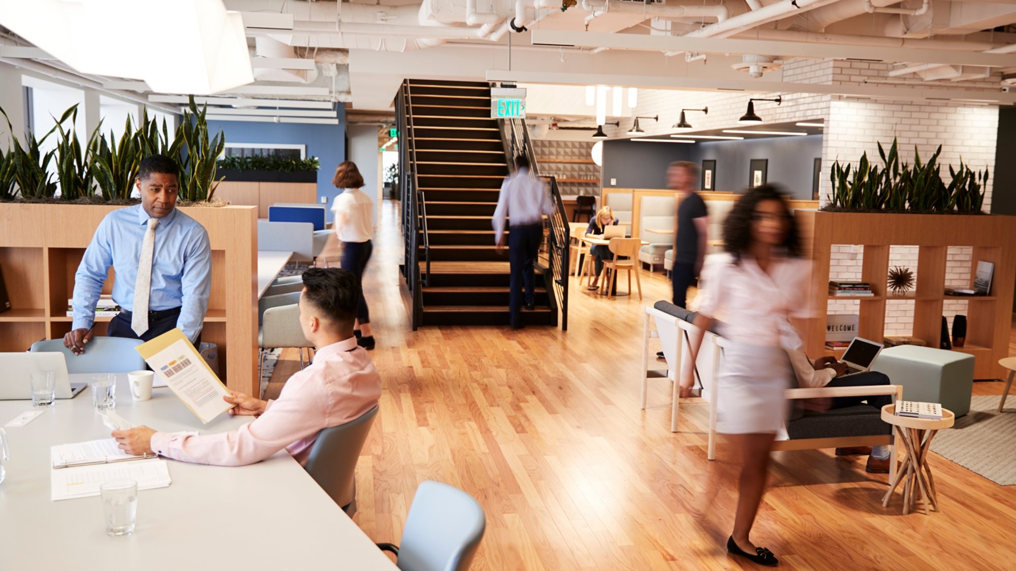 Interior View Of Modern Open Plan Office With Blurred Businessmen And Businesswomen
