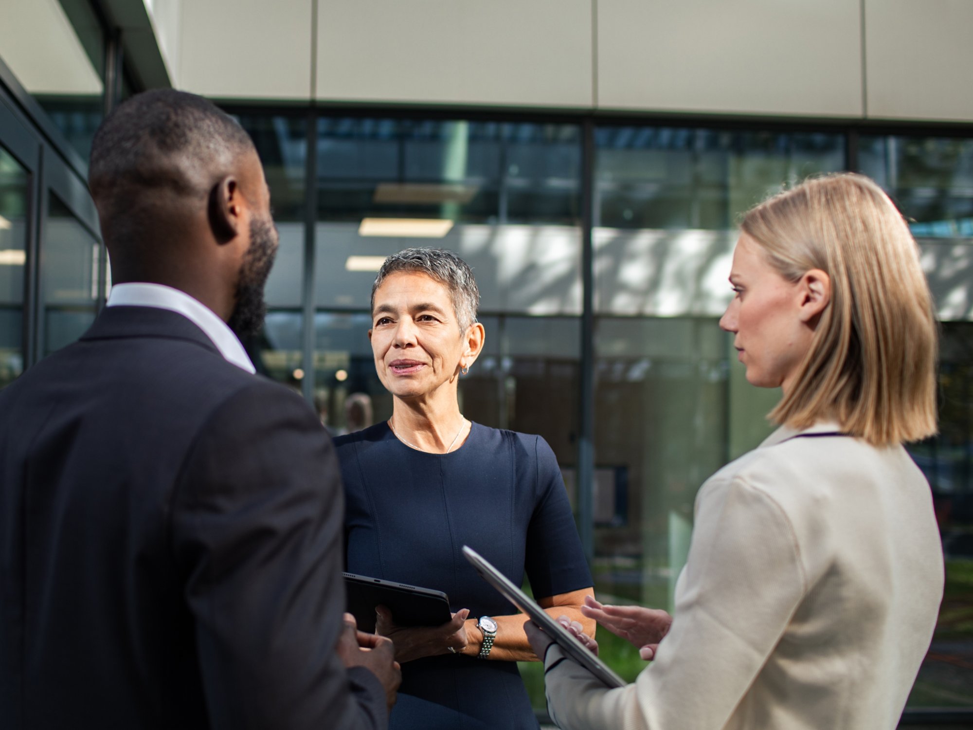 Business professionals discussing project outside office building