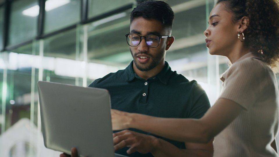 Laptop, meeting and web developers in office with troubleshooting online problem. Computer, conversation and IT professionals with technology for website crash, mistake or error in workplace