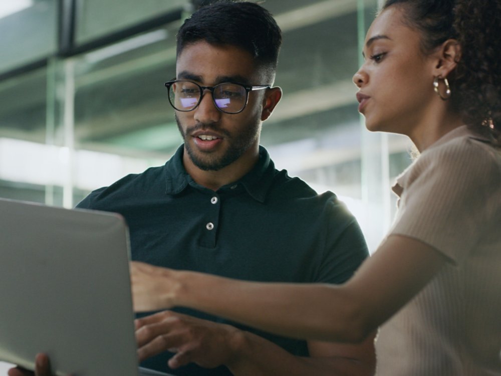 Laptop, meeting and web developers in office with troubleshooting online problem. Computer, conversation and IT professionals with technology for website crash, mistake or error in workplace