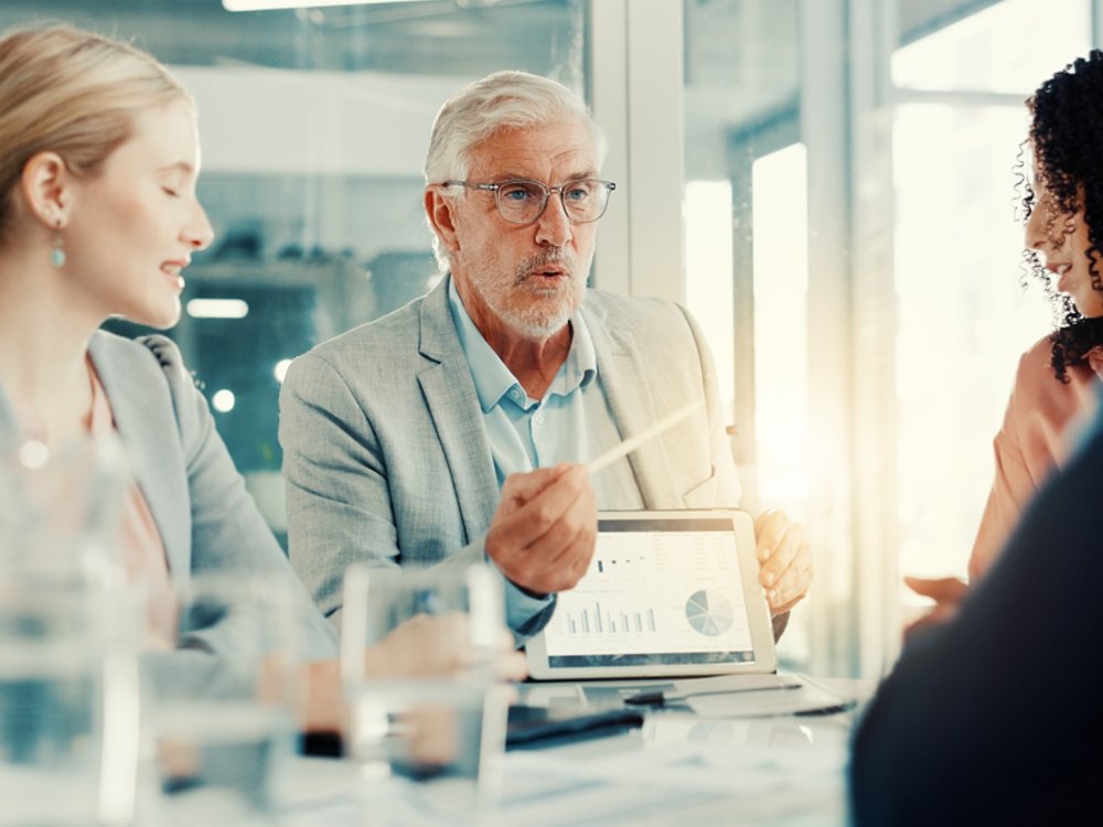 Presentation, businessman and tablet screen with charts in meeting, investment metrics or planning. Office, team or brainstorming with financial dashboard, data or performance analysis with kpi stats.