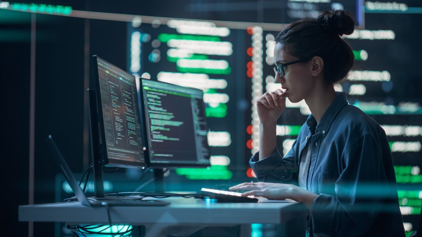 Female Developer Thinking and Typing on Computer, Surrounded by Big Screens Showing Coding Language. Focused Programmer Creating Software, Running Coding Tests. Futuristic Concept of Programming