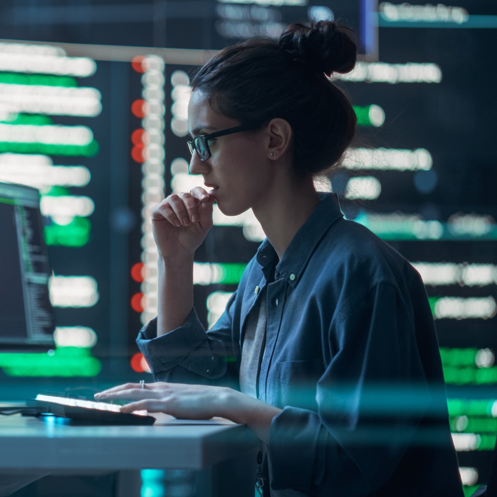 Female Developer Thinking and Typing on Computer, Surrounded by Big Screens Showing Coding Language. Focused Programmer Creating Software, Running Coding Tests. Futuristic Concept of Programming
