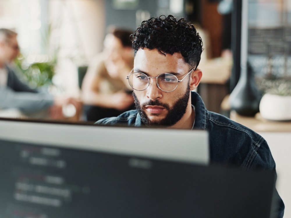 Coding, computer and web development with man in creative workplace for design or programming. Cyber security, language and system maintenance with employee person in office as website developer.