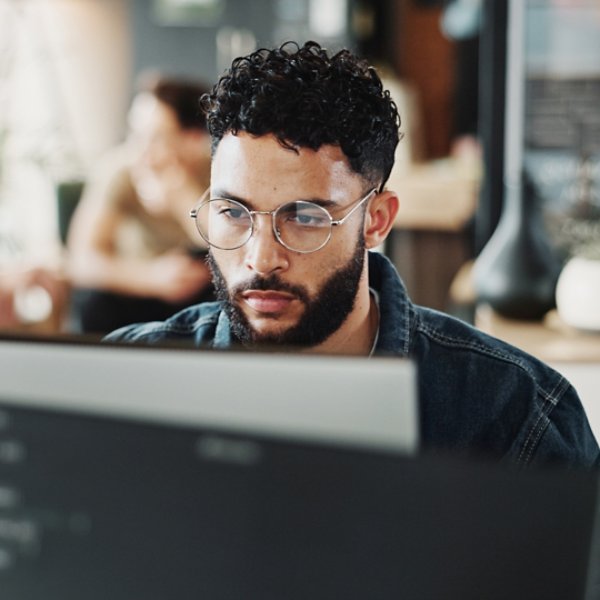 Coding, computer and web development with man in creative workplace for design or programming. Cyber security, language and system maintenance with employee person in office as website developer.