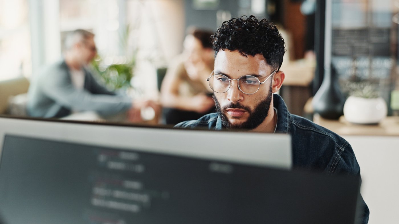 Coding, computer and web development with man in creative workplace for design or programming. Cyber security, language and system maintenance with employee person in office as website developer.