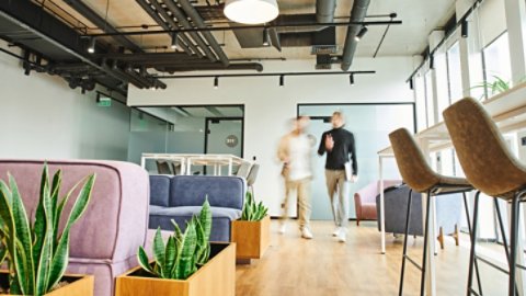motion blur of business partners walking in lounge of contemporary coworking environment with high tech interior, modern furniture and natural plants, dynamic business and productivity concept