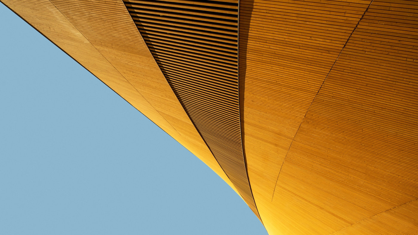 Abstract shape of modern wooden building against blue background, elegant minimalist geometric architecture