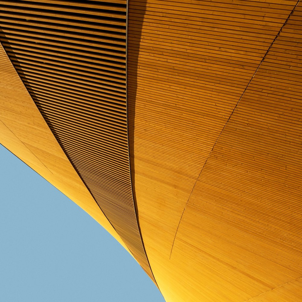 Abstract shape of modern wooden building against blue background, elegant minimalist geometric architecture