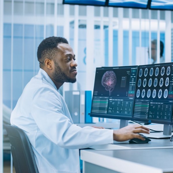 Medical Scientist Working with CT Brain Scan Images on a Personal Computer in Laboratory. Neurologists in Neurological Research Center Working on a Brain Tumor Cure.