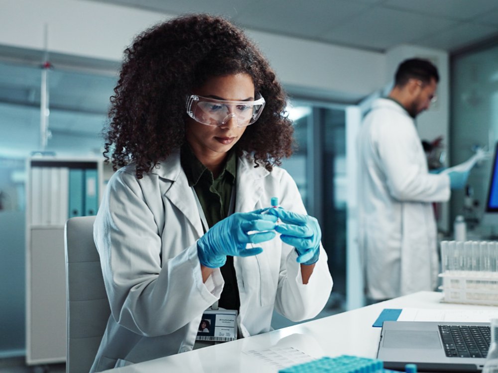 Woman, scientist or blood vial for exam in laboratory, healthcare or pathology to label on test tube. Biotechnology, pharmaceutical and laptop by doctor and online scientific results in phlebotomy.
