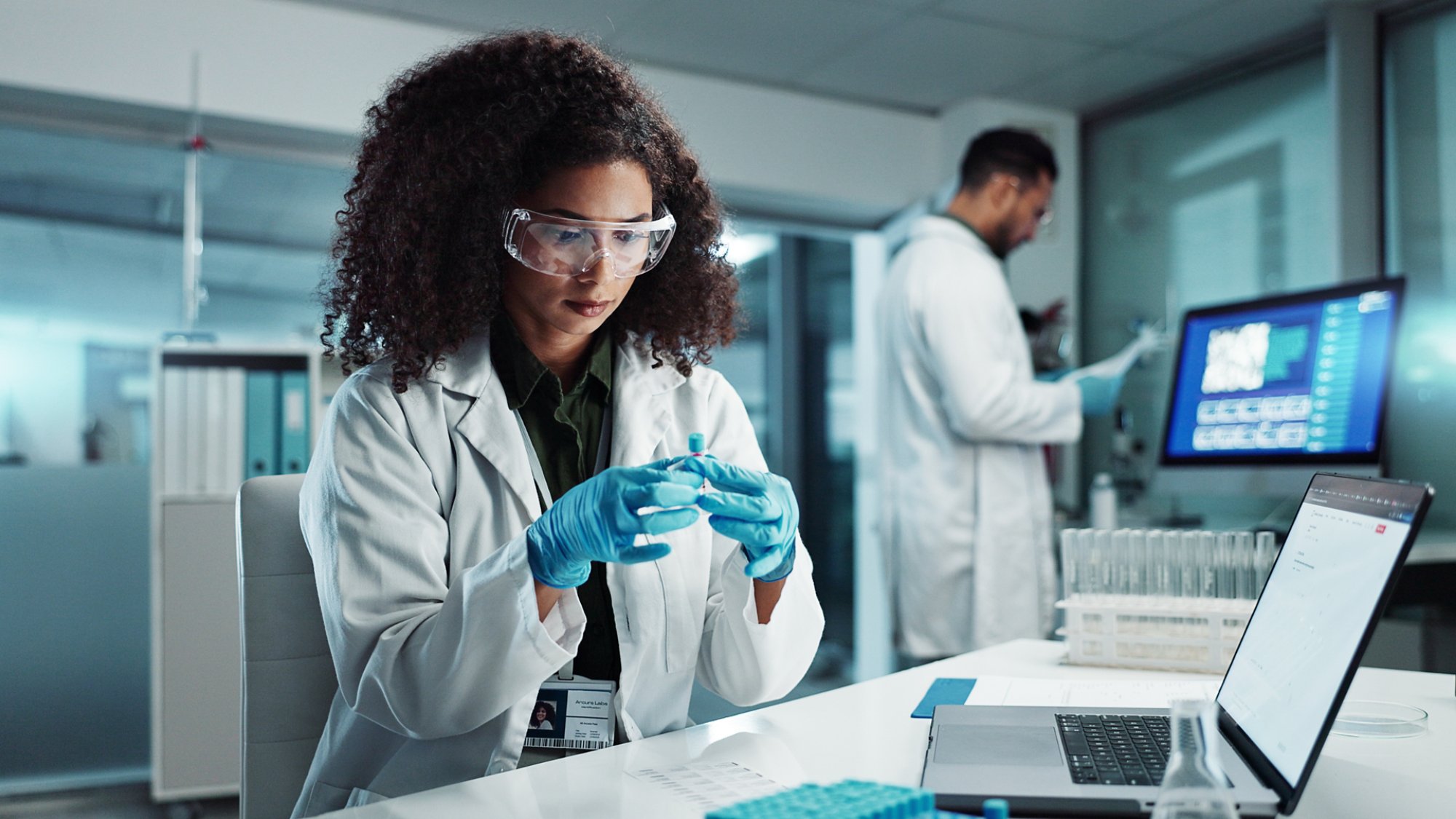 Woman, scientist or blood vial for exam in laboratory, healthcare or pathology to label on test tube. Biotechnology, pharmaceutical and laptop by doctor and online scientific results in phlebotomy.