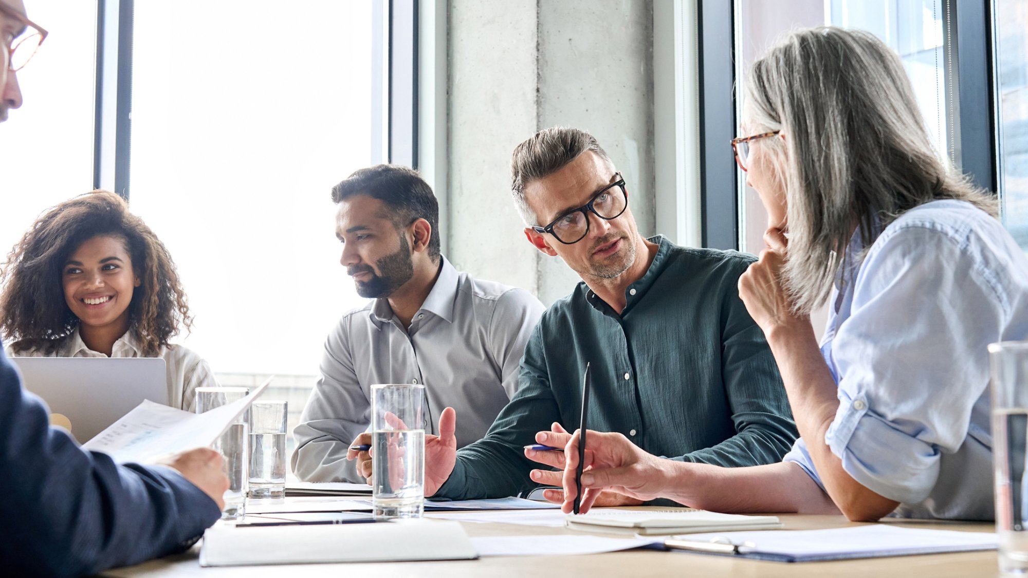 Diverse business people partners group negotiating at boardroom meeting.Multiethnic executive team discussing financial partnership agreement project strategy brainstorming sitting at table in office.