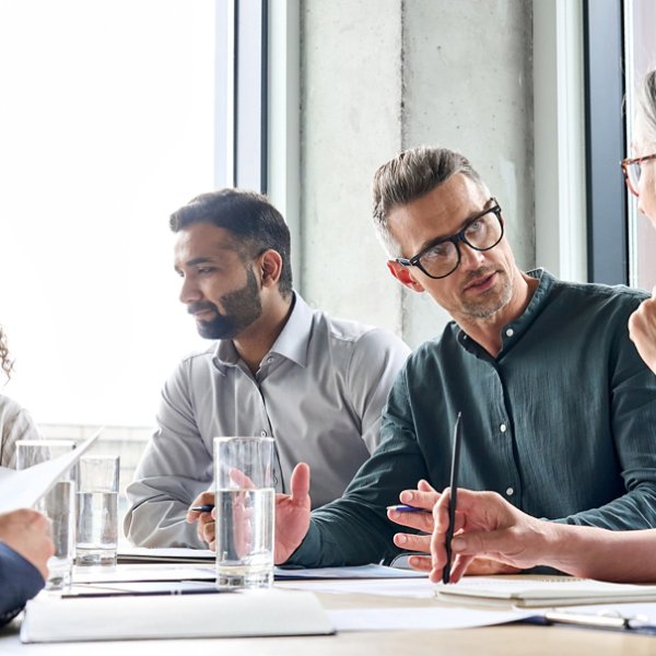 Diverse business people partners group negotiating at boardroom meeting.Multiethnic executive team discussing financial partnership agreement project strategy brainstorming sitting at table in office.