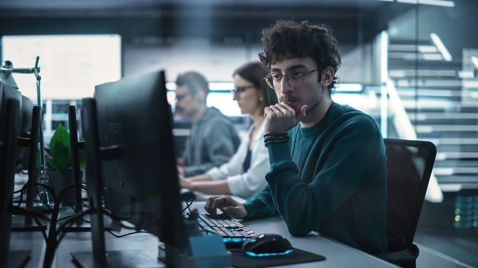 Young Handsome Software Developer Working on Computer in a Technological Laboratory Environment. IT Programming Department Tirelessly Researching and Developing Advanced Commercial Internet Products