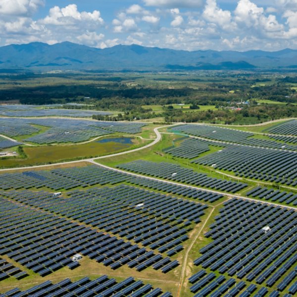 Aerial view of many solar energy modules or panels rows pattern over the green landscape