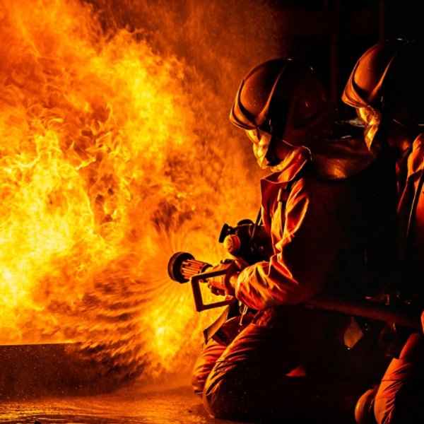 Panoramic firefighters using Twirl water fog type fire extinguisher to fighting with the fire flame from oil to control fire not to spreading out. Firefighter and industrial safety concept.