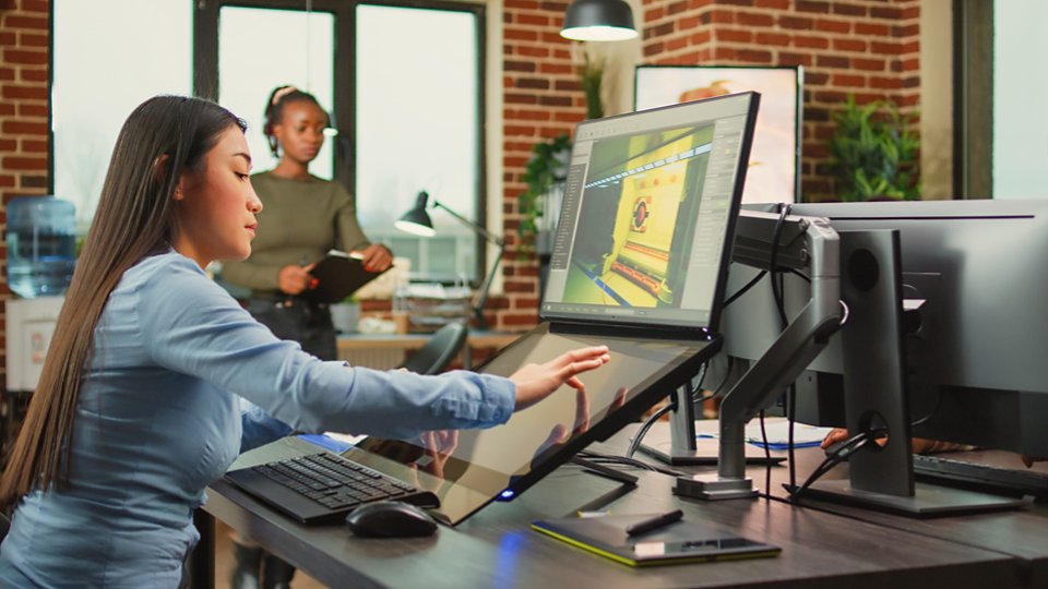 Employee game developer working in creative production department to create professional web content in office. Asian woman developing 3D graphics components with engineering software