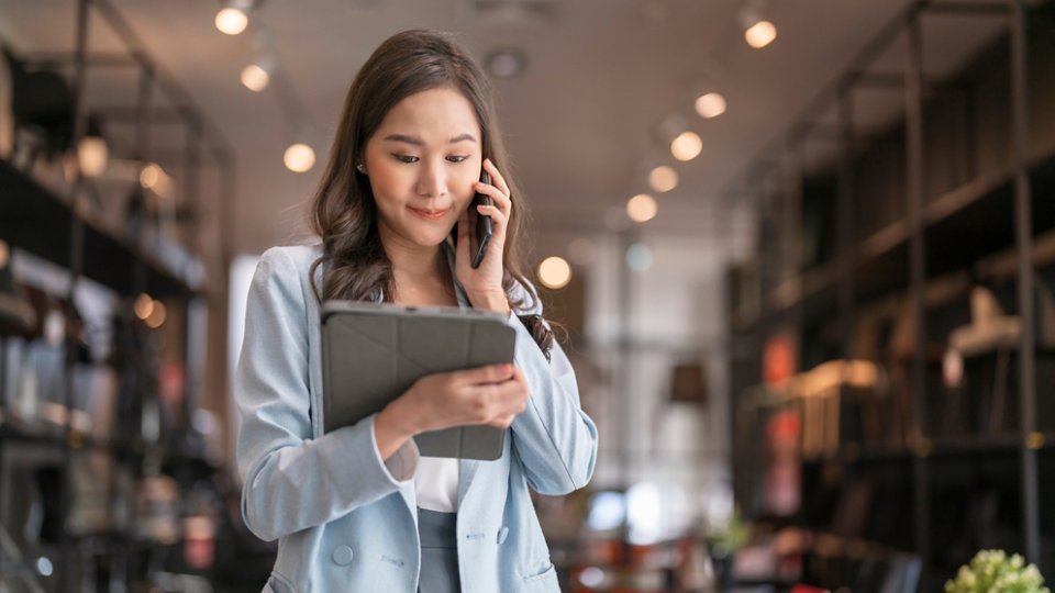 smart business owner asian female startup entrepreneur small business manager businesswoman wear smart casual cloth smile hand use tablet smartphone working inventory checking in showroom studio