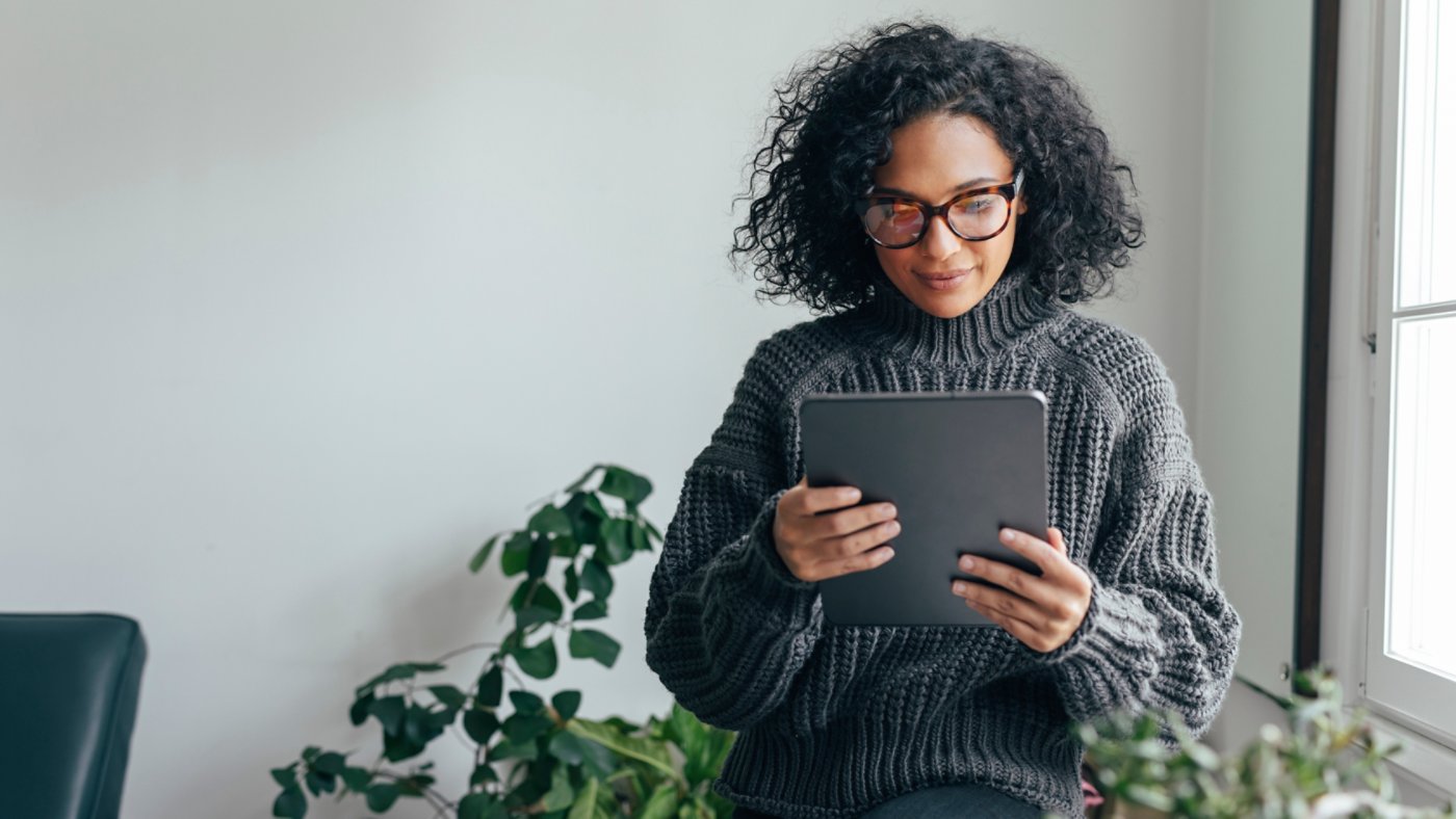 Young woman wearing glasses watching something on her digital tablet (copy space).