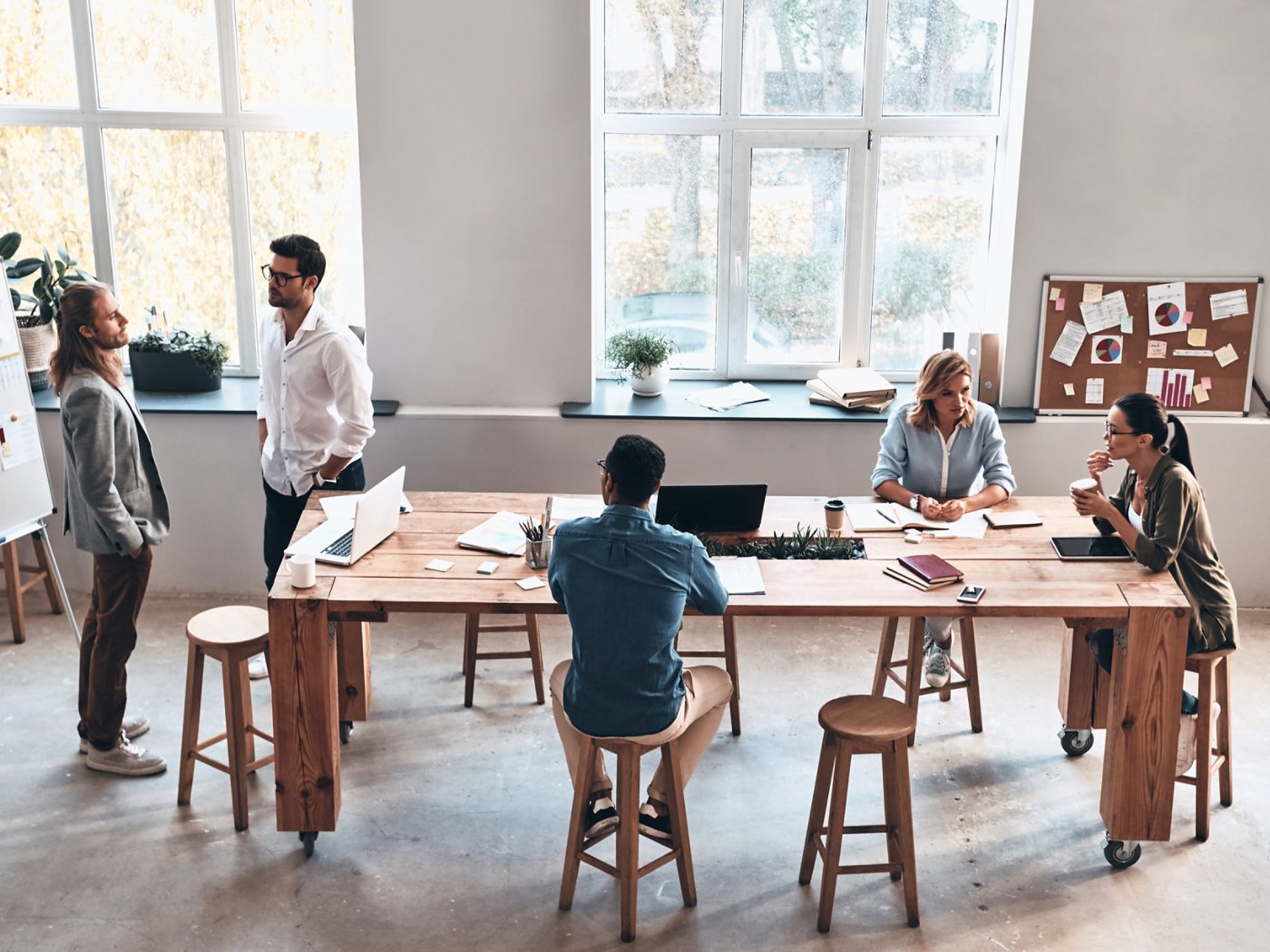 Top view of modern young people communicating while working together in the board room