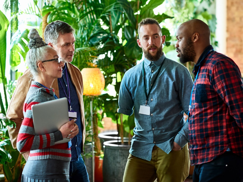 Professionals attending conference chatting in office breakout area, networking, opportunity, business development