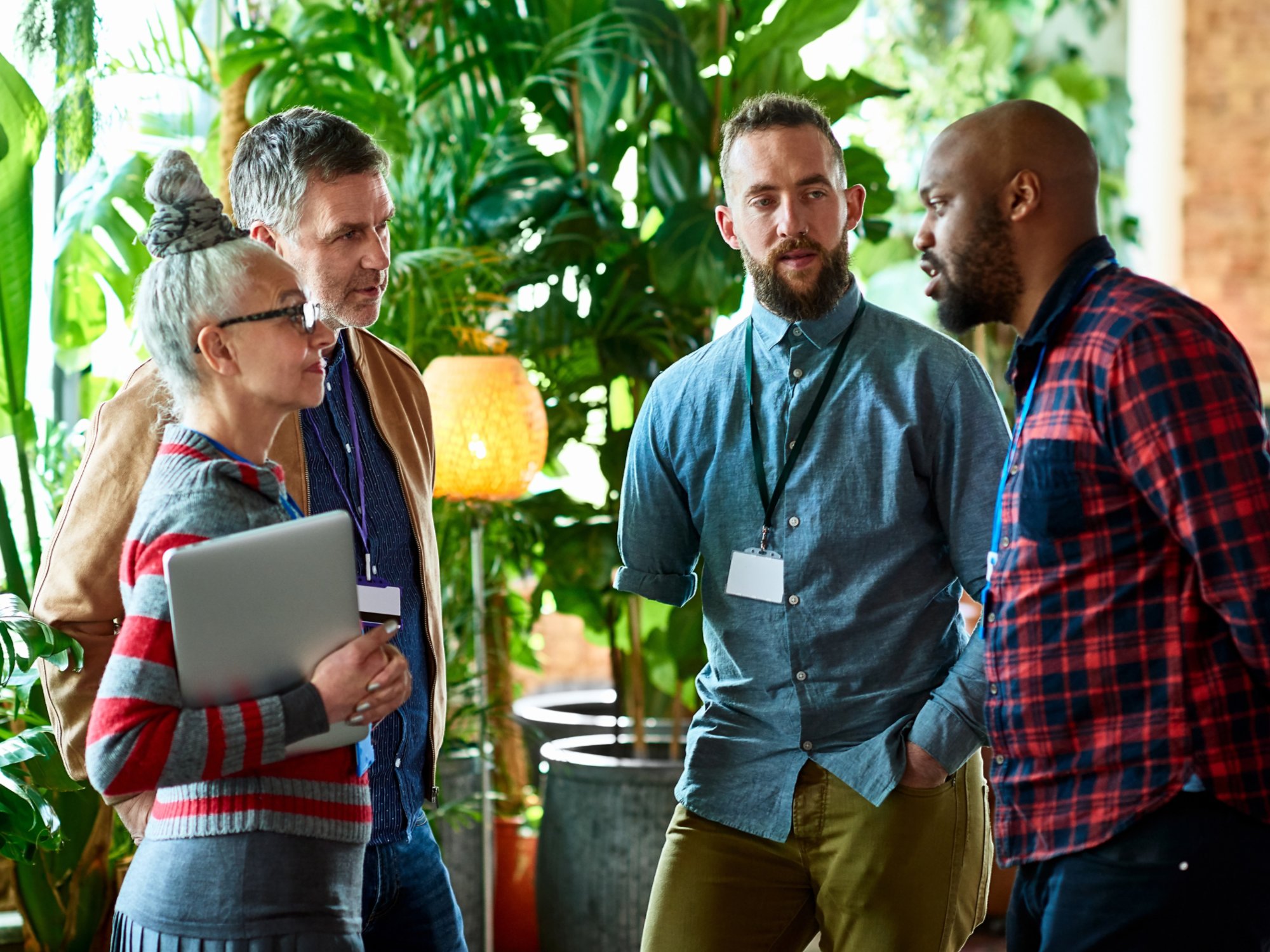 Professionals attending conference chatting in office breakout area, networking, opportunity, business development