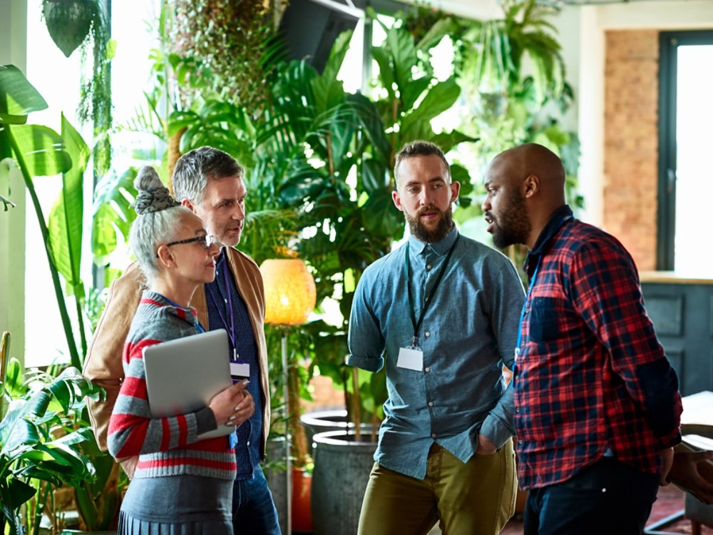 Professionals attending conference chatting in office breakout area, networking, opportunity, business development