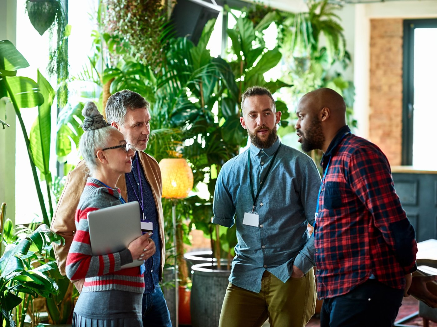 Professionals attending conference chatting in office breakout area, networking, opportunity, business development