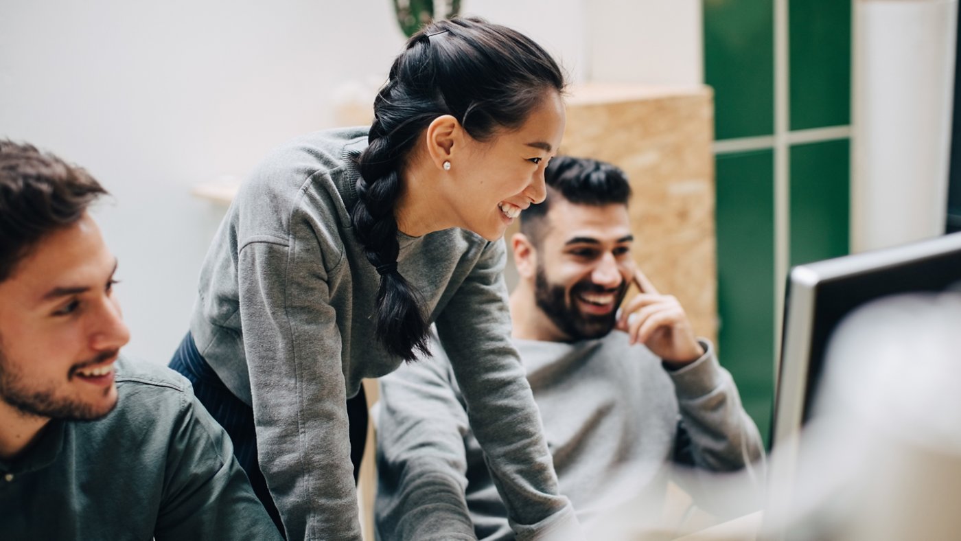 Two people at work discussing with female leading 16X9