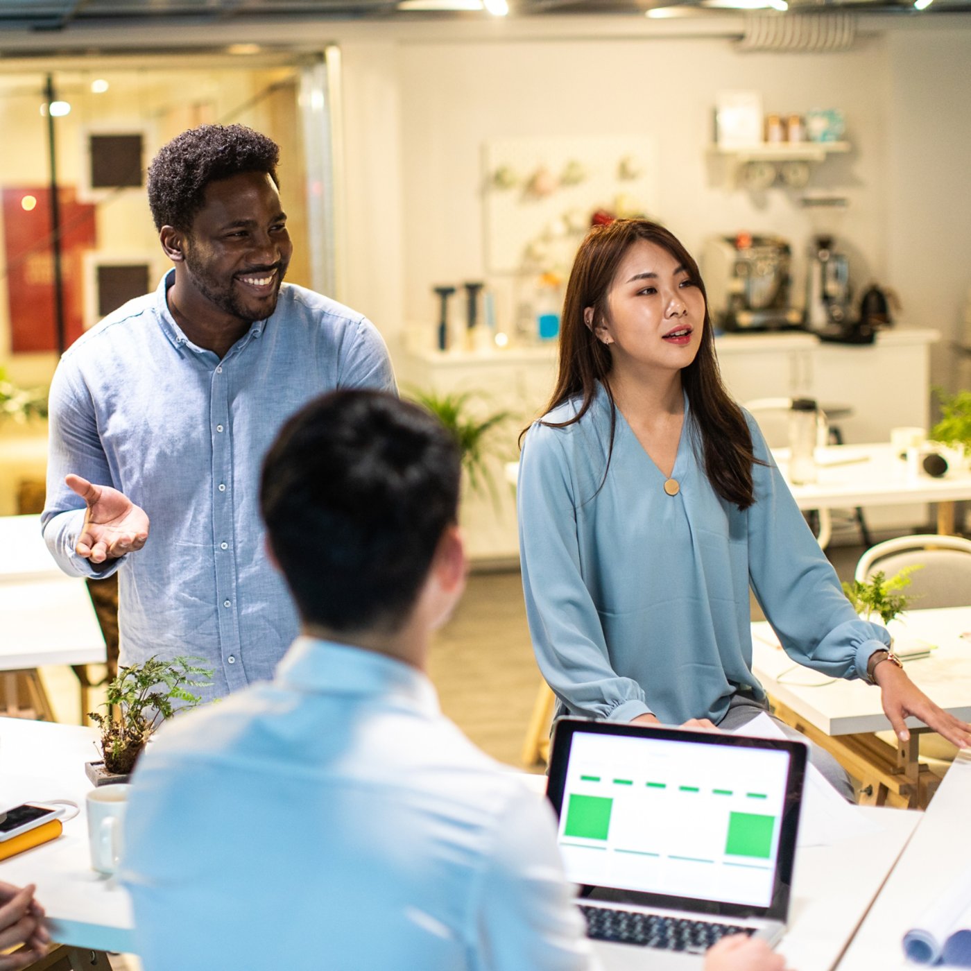 Group of young, modern people sitting on business meeting in modern coworking space and suggesting ideas for the best business strategy 1X1