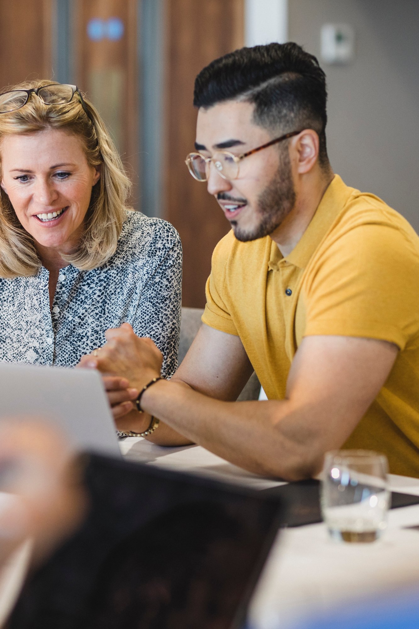 Mature businesswoman smiling with employee, working together, collaboration, teamwork