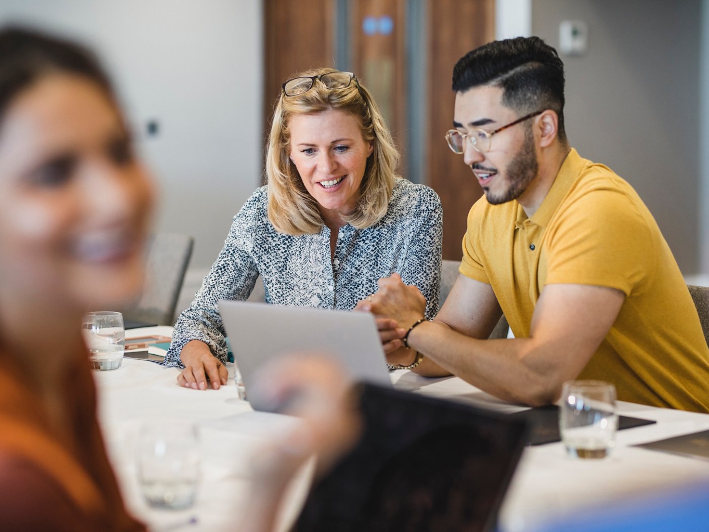 Mature businesswoman smiling with employee, working together, collaboration, teamwork