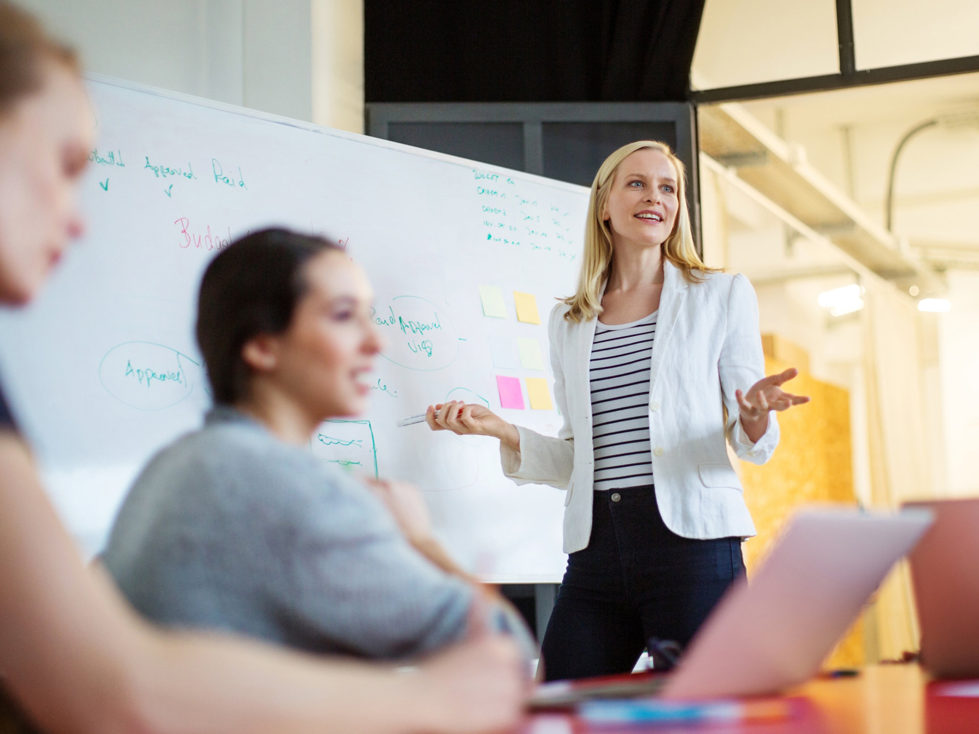 Young businesswoman giving presentation on future plans to her colleagues at office