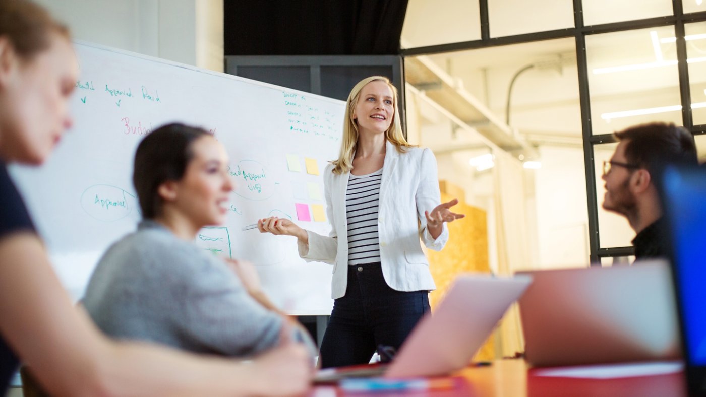 Young businesswoman giving presentation on future plans to her colleagues at office