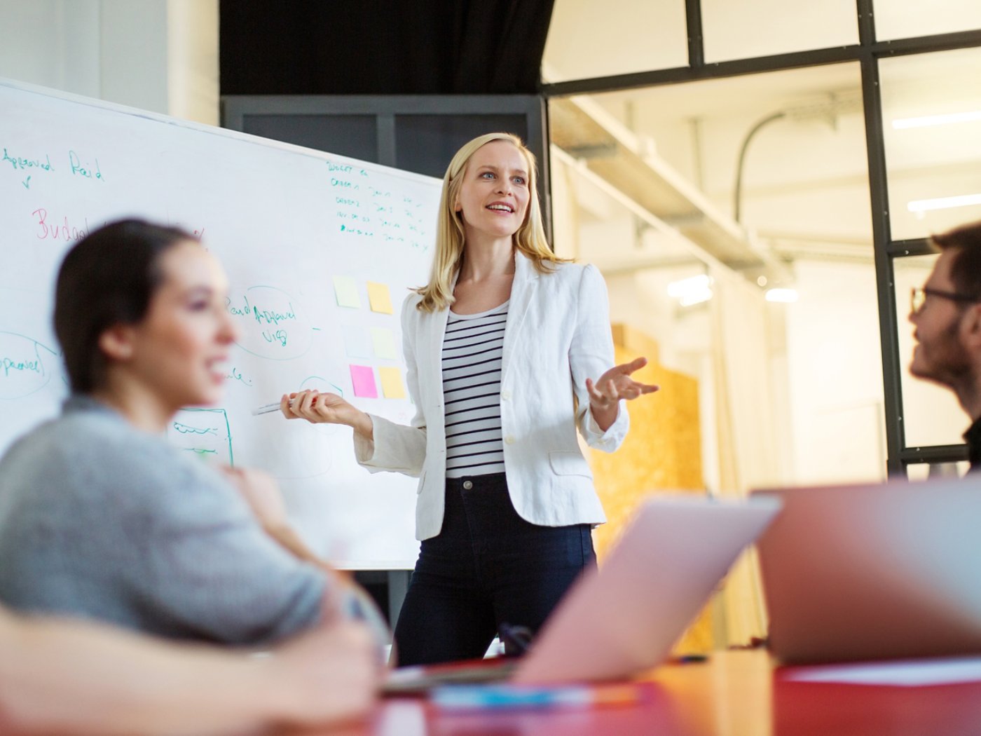 Young businesswoman giving presentation on future plans to her colleagues at office