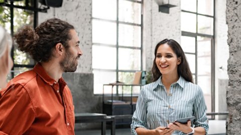 Group of successful businesspeople cooperating by participating in a casual meeting around a standing desk.