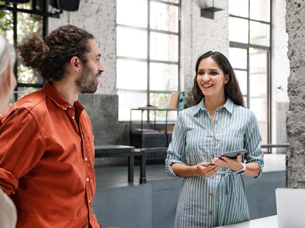 Group of successful businesspeople cooperating by participating in a casual meeting around a standing desk.