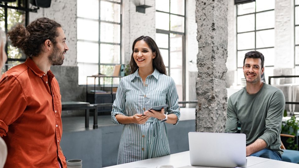 Group of successful businesspeople cooperating by participating in a casual meeting around a standing desk.