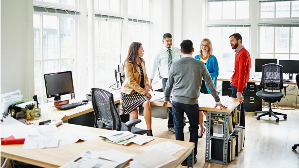 Group of coworkers discussing project at table in office