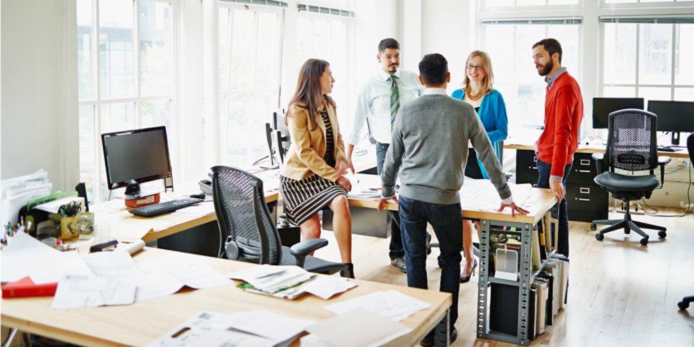 Group of coworkers discussing project at table in office