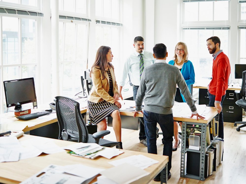 Group of coworkers discussing project at table in office