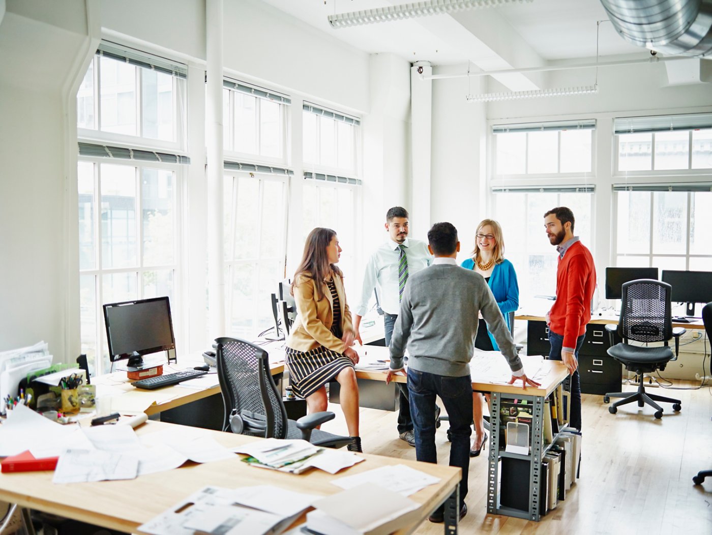 Group of coworkers discussing project at table in office