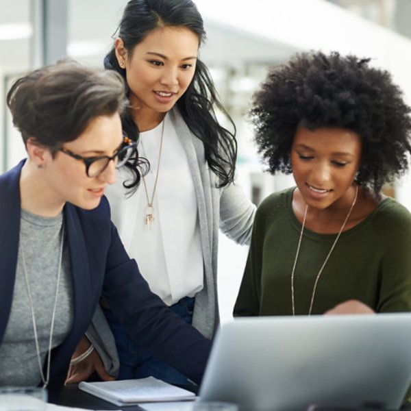 Shot of a group of businesswomen using a laptop during a meeting at work