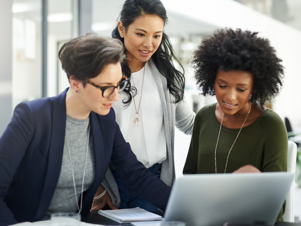 Shot of a group of businesswomen using a laptop during a meeting at work