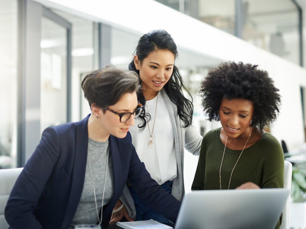 Shot of a group of businesswomen using a laptop during a meeting at work
